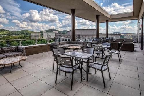 a patio with tables and chairs on a balcony at Hilton Franklin Cool Springs in Franklin