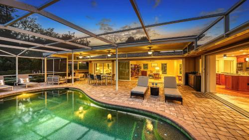 a house with a swimming pool and a patio at Gulf Birdie - 5551 in Siesta Key
