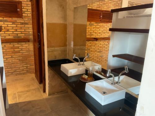 a bathroom with two sinks on a black counter at BEACH HOUSE - Loggia Suite 4 - com cozinha - na praia -BEACHFRONT in Barra Grande