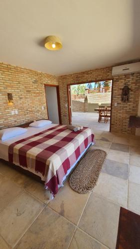 a bedroom with a large bed in a brick wall at BEACH HOUSE - Loggia Suite 4 - com cozinha - na praia -BEACHFRONT in Barra Grande
