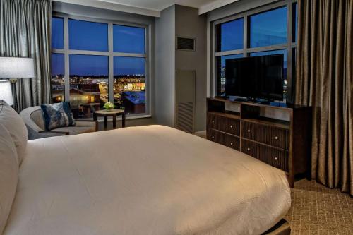 a bedroom with a large bed and a large window at Hilton Nashville Green Hills in Nashville