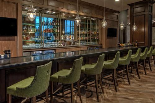 a bar with a row of green stools at Hilton Nashville Green Hills in Nashville