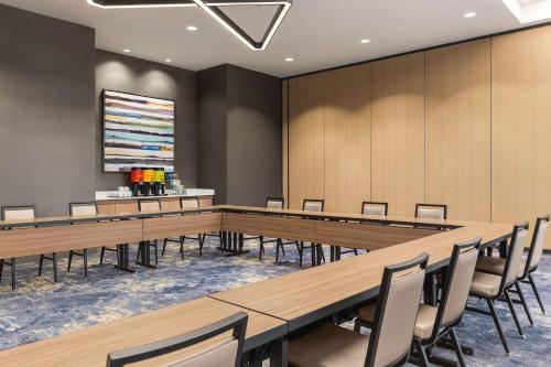 a large conference room with wooden tables and chairs at Home2 Suites By Hilton Nashville West End Avenue in Nashville