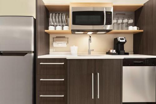 a kitchen with a refrigerator and a microwave at Home2 Suites By Hilton Nashville West End Avenue in Nashville