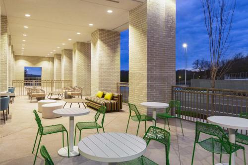 a patio with tables and chairs on a balcony at Hilton Garden Inn Nashville West End Avenue in Nashville