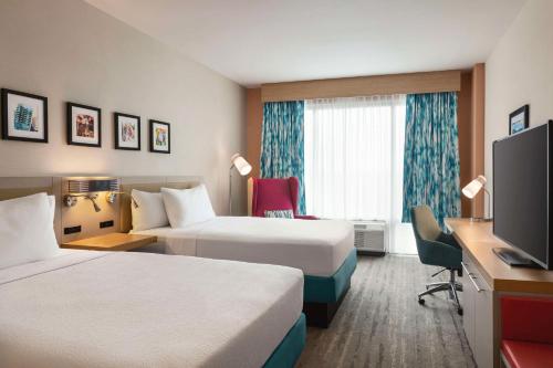a hotel room with two beds and a flat screen tv at Hilton Garden Inn Nashville West End Avenue in Nashville