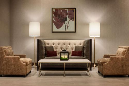 a living room with a couch and two chairs at Hilton Garden Inn Charlotte Southpark in Charlotte