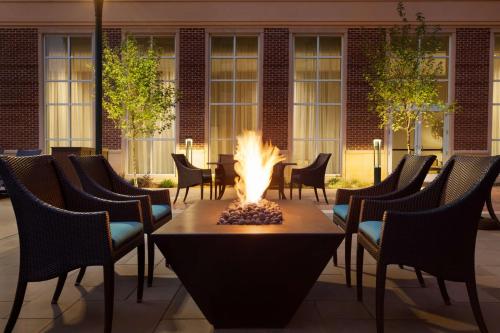 a fire pit in a courtyard with chairs and a building at Homewood Suites By Hilton Charlotte Southpark in Charlotte