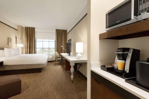 a hotel room with a bed a desk and a tv at Hilton Garden Inn Charlotte Southpark in Charlotte