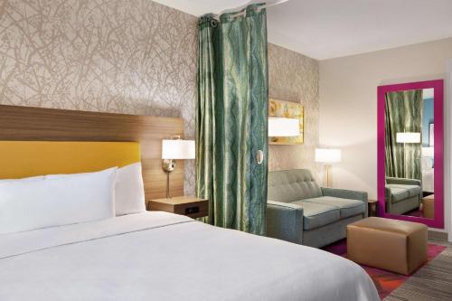 a hotel room with a bed and a couch at Home2 Suites By Hilton Colorado Springs South, Co in Colorado Springs