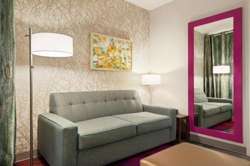 a living room with a couch and a mirror at Home2 Suites By Hilton Colorado Springs South, Co in Colorado Springs