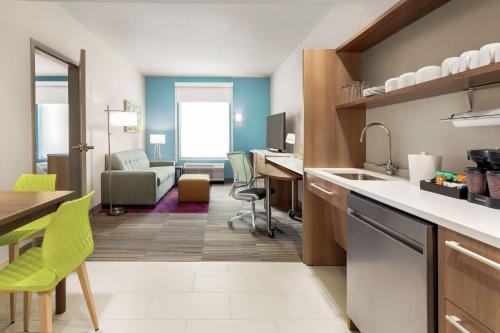 a kitchen and living room with a table and chairs at Home2 Suites By Hilton Colorado Springs South, Co in Colorado Springs