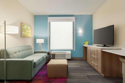 a living room with a couch and a flat screen tv at Home2 Suites By Hilton Colorado Springs South, Co in Colorado Springs
