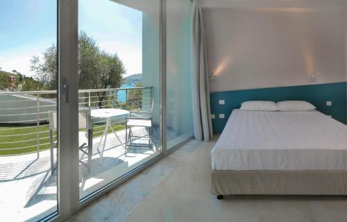 a bedroom with a bed and a balcony with a table at Cristallo Park Hotel in Portovenere