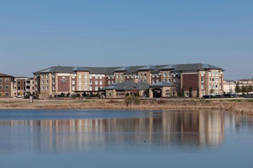 ein großes Gebäude neben einem großen Wasserkörper in der Unterkunft Homewood Suites Denton in Denton