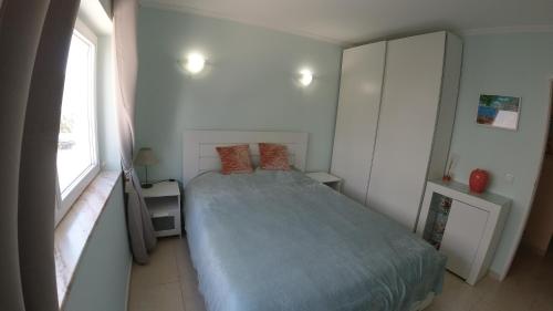 ein kleines Schlafzimmer mit einem Bett und einem Fenster in der Unterkunft PORTUGAL HOLIDAYS in Luz