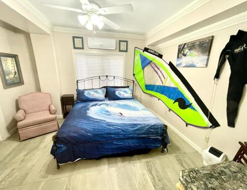 a bedroom with a bed and a surfboard on the wall at Hummingbird in Utila