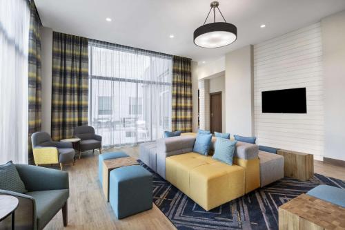 a living room with a couch and a tv at Hampton Inn Boston Woburn in Woburn