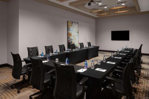 a conference room with long tables and chairs and a screen at Homewood Suites Springfield in Springfield