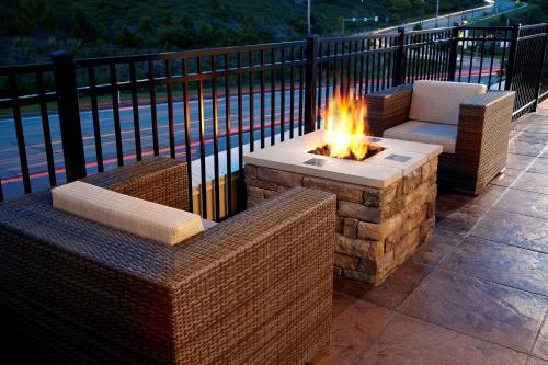 a fire pit on a patio with two wicker chairs at Hampton Inn & Suites Pittsburgh Airport South/Settlers Ridge in Robinson Township