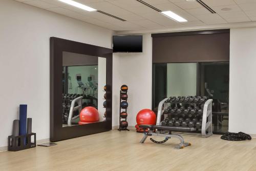 a room with a gym with exercise equipment and mirrors at Homewood Suites by Hilton Pittsburgh Downtown in Pittsburgh