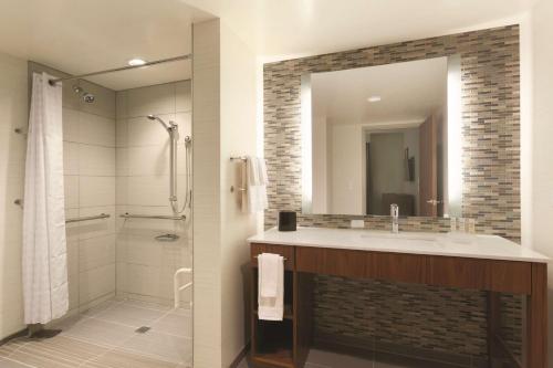 a bathroom with a sink and a shower and a mirror at Homewood Suites by Hilton Pittsburgh Downtown in Pittsburgh