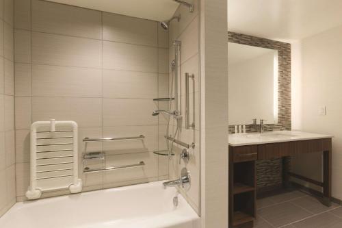 a bathroom with a shower and a tub and a sink at Homewood Suites by Hilton Pittsburgh Downtown in Pittsburgh