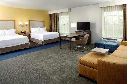 ロビンソン・タウンシップにあるHampton Inn & Suites Pittsburgh Airport South/Settlers Ridgeのベッド2台とデスクが備わるホテルルームです。