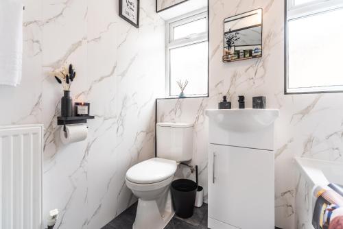 a white bathroom with a toilet and a sink at Hull 3 Bedrooms Garden Central House Sleeps 6 Hosanna MERCI Showy Cozy - Close to Princess Ave in Hull