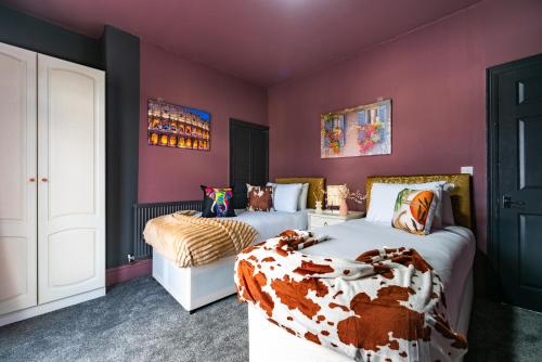 a bedroom with two beds and purple walls at Hull 3 Bedrooms Garden Central House Sleeps 6 Hosanna MERCI Showy Cozy - Close to Princess Ave in Hull