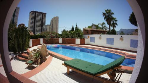 a swimming pool with two lounge chairs next to a building at Villa Vid-Bil Calpe in Calpe