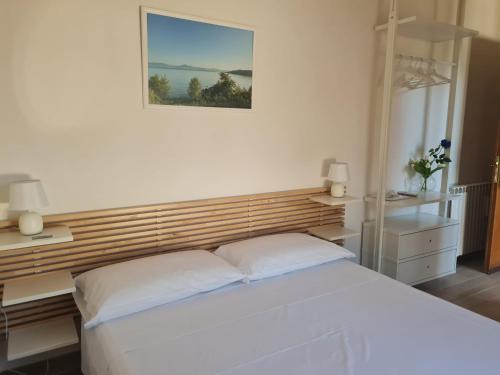a bedroom with a white bed and two lamps at Il Sogno delle Rondini in Palidoro