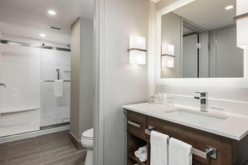 a bathroom with a sink and a toilet and a mirror at Homewood Suites By Hilton Ottawa Downtown in Ottawa