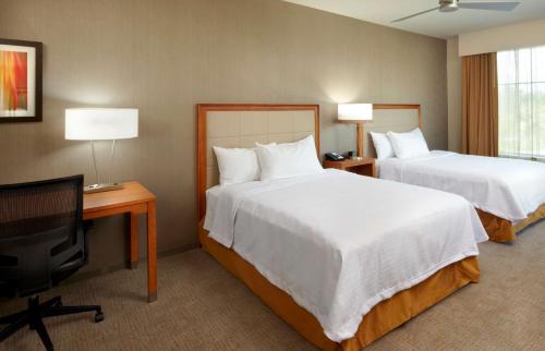 a hotel room with two beds and a flat screen tv at Homewood Suites by Hilton Pittsburgh Airport/Robinson Mall Area in Moon Township