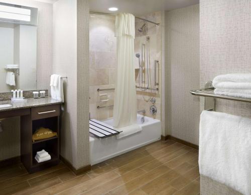 a bathroom with a shower and a tub and a sink at Homewood Suites by Hilton Pittsburgh Airport/Robinson Mall Area in Moon Township