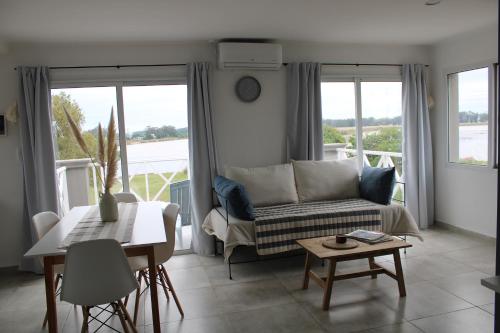 ein Wohnzimmer mit einem Sofa und einem Tisch in der Unterkunft COMPLEJO LA ISLA MAR CHIQUITA in Balneario Mar Chiquita