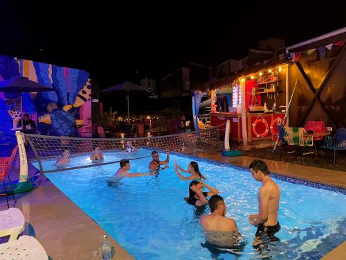 un grupo de personas en una piscina por la noche en Trip Monkey Hostel en San Gil