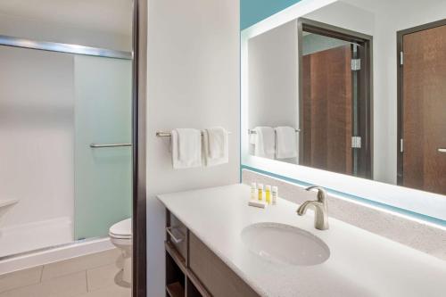 a bathroom with a sink and a toilet and a mirror at Homewood Suites By Hilton Edina Minneapolis in Edina