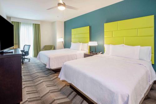 a hotel room with two beds and a flat screen tv at Homewood Suites By Hilton Edina Minneapolis in Edina