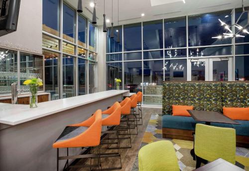 a bar with orange and green chairs and tables at Homewood Suites By Hilton Edina Minneapolis in Edina