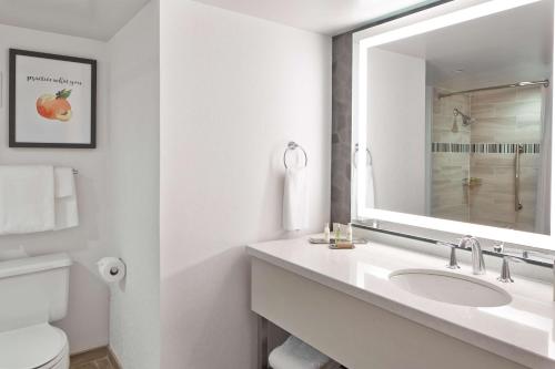 a white bathroom with a sink and a mirror at Doubletree By Hilton Atlanta Perimeter Dunwoody in Atlanta
