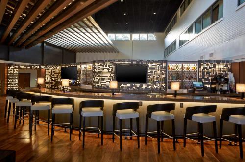 a bar with white stools in a room at Doubletree By Hilton Atlanta Perimeter Dunwoody in Atlanta