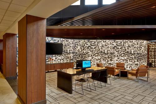 a lobby with a desk with a television and chairs at Doubletree By Hilton Atlanta Perimeter Dunwoody in Atlanta