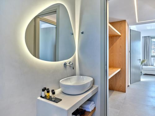 een badkamer met een wastafel en een spiegel bij Paros Gem in Naousa
