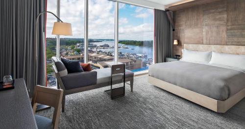 um quarto de hotel com uma cama e uma grande janela em Canopy By Hilton Washington DC The Wharf em Washington