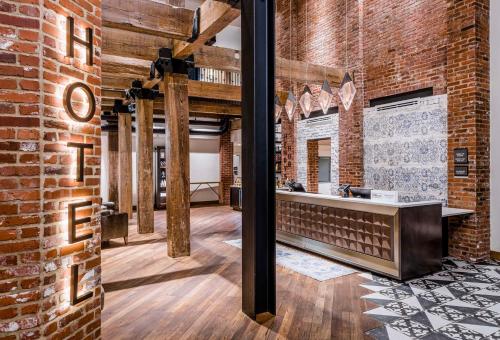 a room with a brick wall and a counter at The Wilbur Lititz, Tapestry Collection By Hilton in Lititz