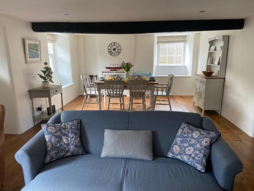 ein Wohnzimmer mit einem blauen Sofa und einem Tisch in der Unterkunft Wayside Cottage - Cosy Cottage in Somerset in Evercreech