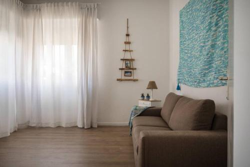 a living room with a couch and a window at Perla Marina Appartamento in Rimini