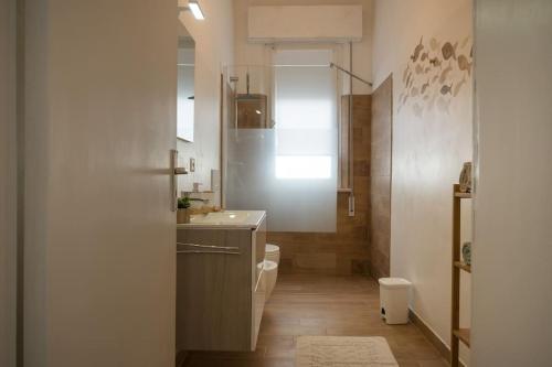 a bathroom with a sink and a toilet and a mirror at Perla Marina Appartamento in Rimini