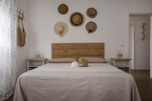 um quarto com uma cama grande com chapéus na parede em Perla Marina Appartamento em Rimini